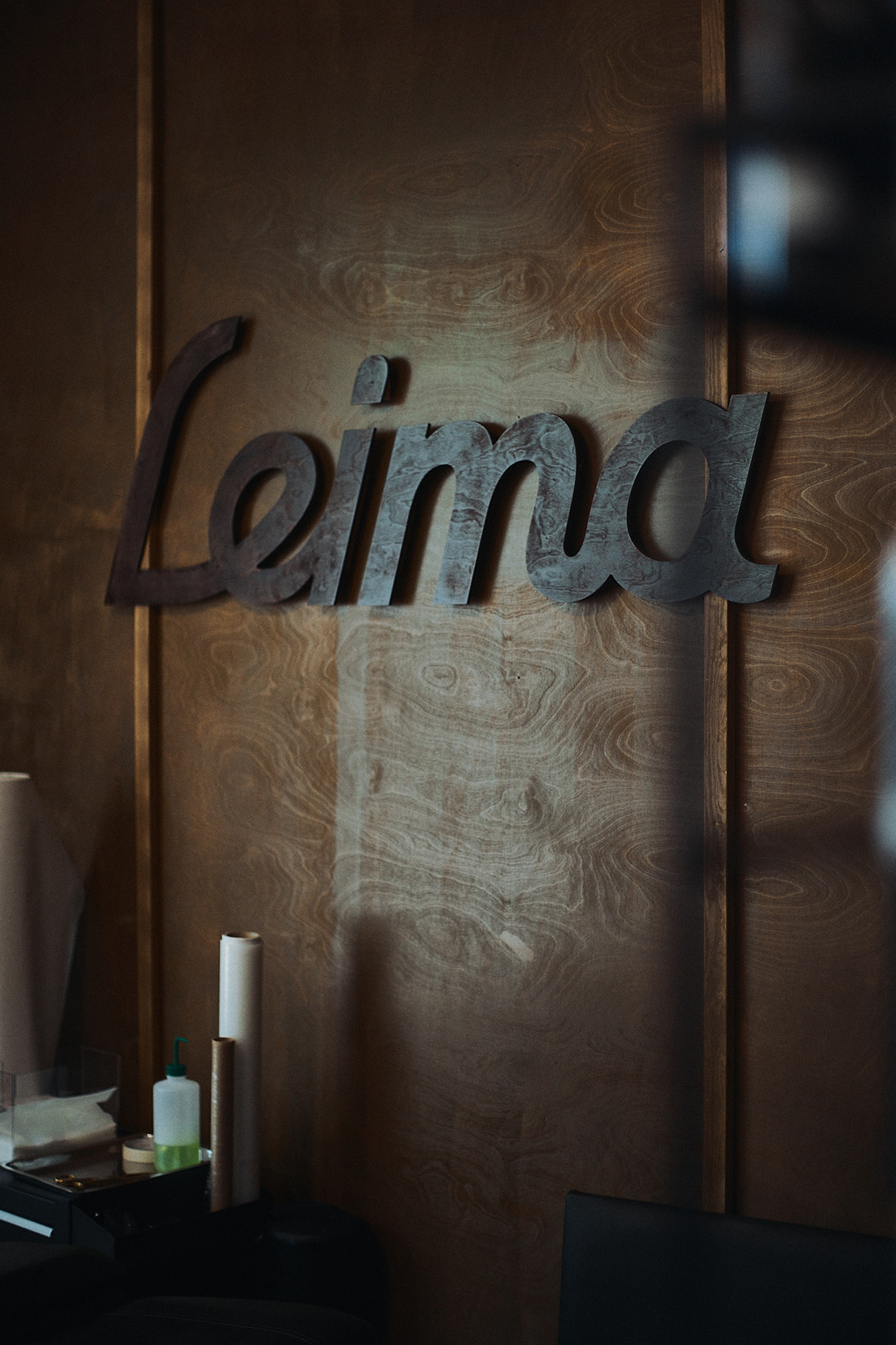 Tatuointiliike Leiman puinen takaseinä johon kiinnitetty petsattu Leima-logo.