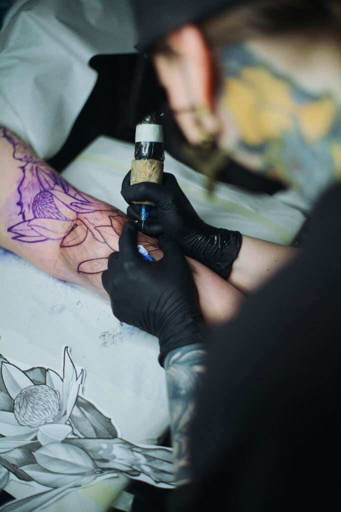 Tatuoija Jole tatuoi asiakkaan käsivartta.