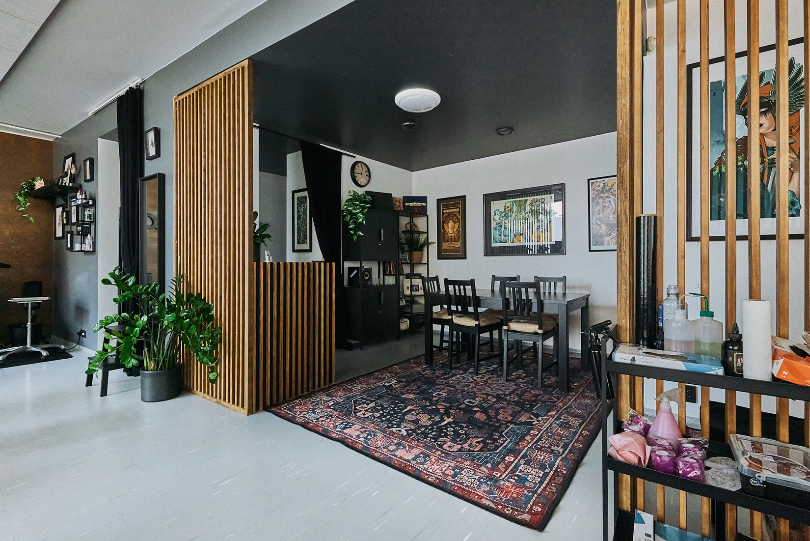 Tatuointiliike Leiman asiakastilat. Tilassa näkyy iso pöytä, matto ja paljon tauluja seinällä.