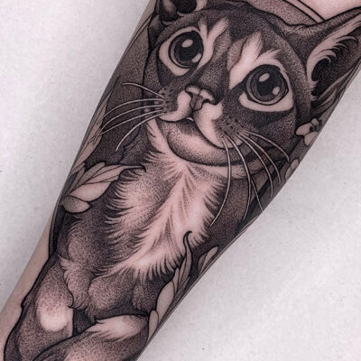 Tatuoija Jolen tekemä kissatatuointi käsivarressa. Tatuointityyli on blackwork. Tatuointi on tehty tatuointiliike Leimassa.