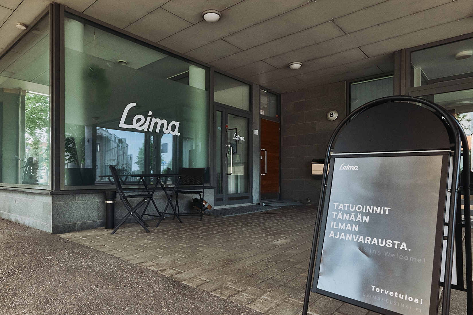 Tatuointiliike Leiman sisäänkäynti kadulta katsottuna osoitteessa Suolakivenkatu 20 b, Helsinki. Edustalla kyltti.